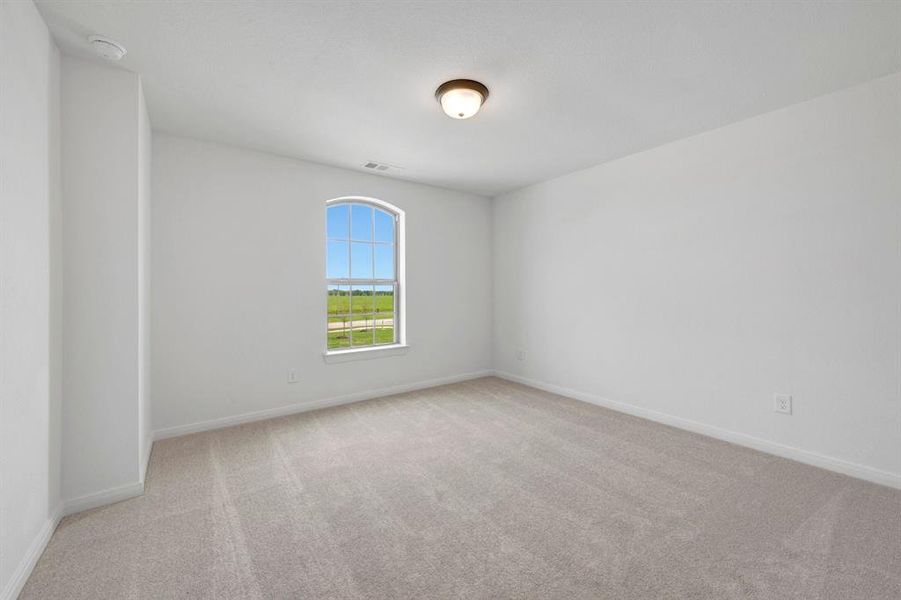 Carpeted interior space featuring an arched window, white walls, and a flush mount ceiling light