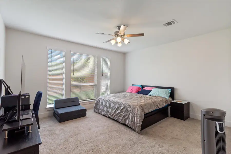 Bedroom featuring light colored carpet and a ceiling fan