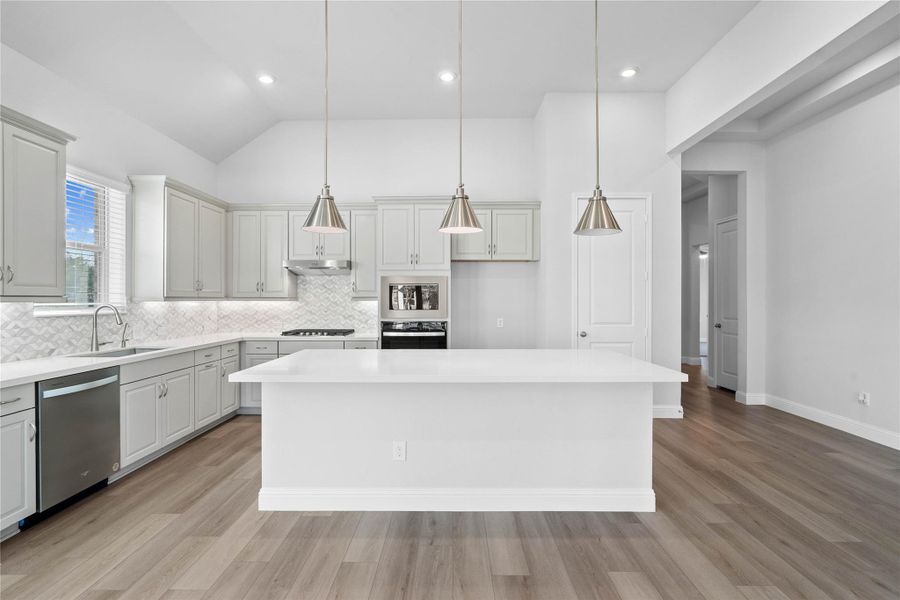 The oversized island offers generous prep and gathering space, complemented by clean-lined cabinetry, modern lighting, and warm flooring that adds a welcoming touch throughout. A perfect backdrop for hosting or relaxing at home. The oversized island offers generous prep and gathering space, complemented by clean-lined cabinetry, modern lighting, and warm flooring that adds a welcoming touch throughout. A perfect backdrop for hosting or relaxing at home.