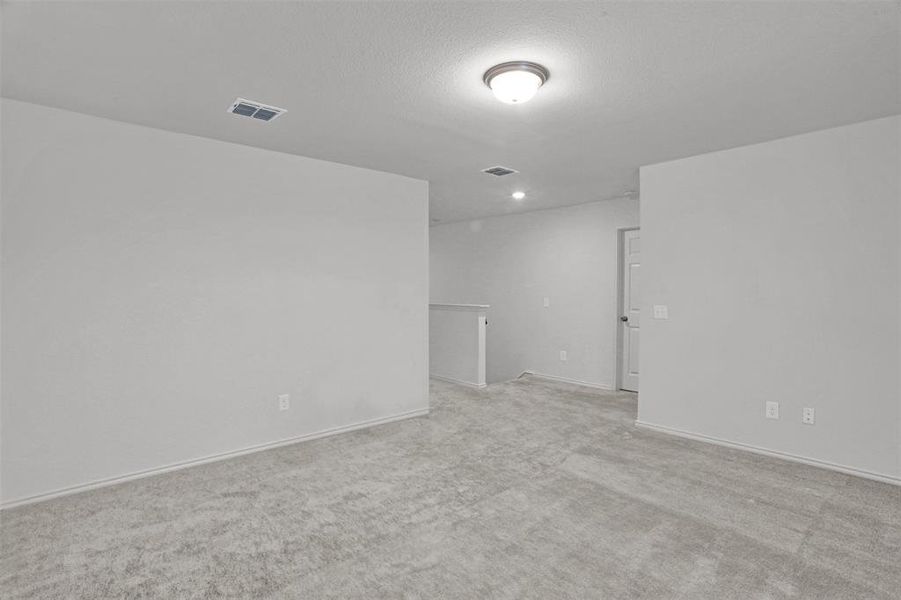 Open concept area featuring light grey wall paint and light grey carpeting, recessed lighting, and a white ceiling with a flush-mount light fixture