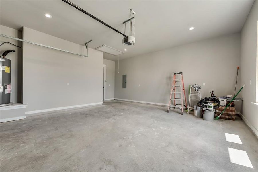 Garage featuring electric panel, a garage door opener, and water heater