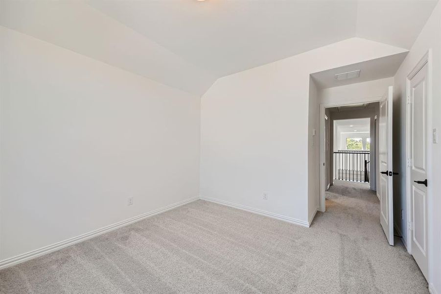 Spare room with light carpet and vaulted ceiling