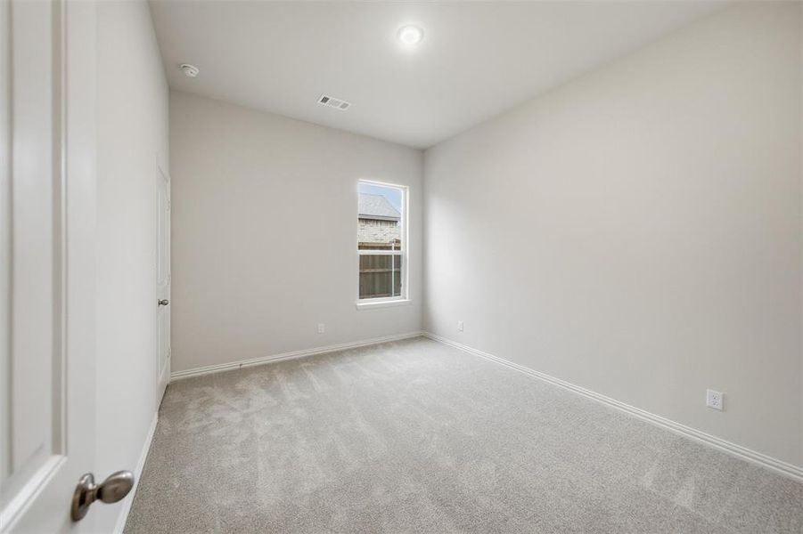 Empty room with light carpet and baseboards Empty room with light carpet and baseboards