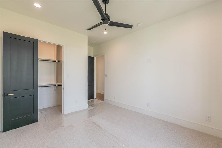 Unfurnished bedroom featuring recessed lighting, ceiling fan, light colored carpet, and a spacious closet