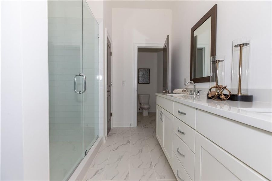 Owners Bathroom features quartz countertops with upgraded tiled walk in shower *Home is Under Construction. Photos shown are from other TPG Communities to display how the home will live*