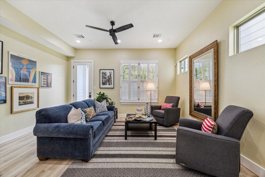 Bright and inviting living room featuring modern furniture, a large mirror, and stylish decor. Natural light flows through the windows, creating a warm atmosphere. Perfect for relaxation and entertaining.