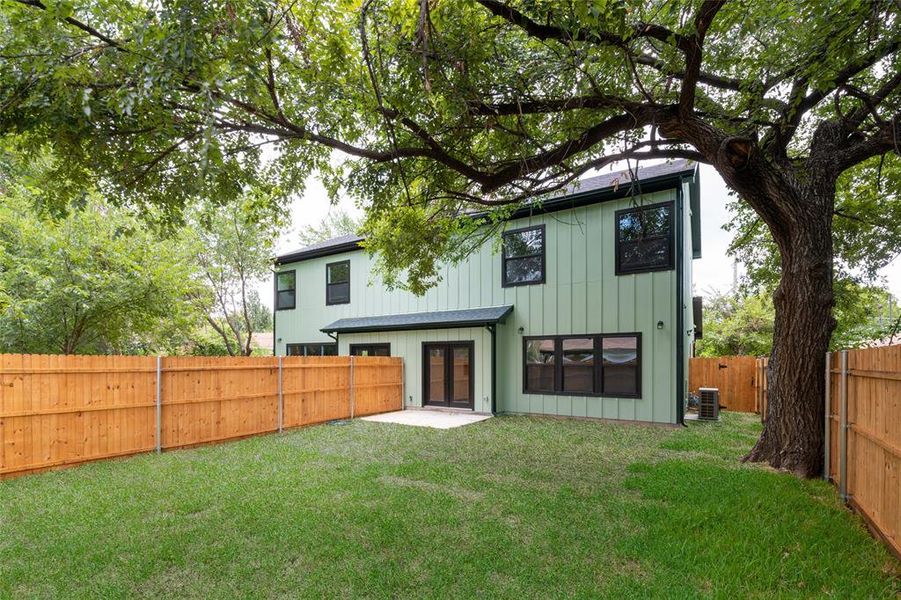 Rear view of property featuring cooling unit, back yard, and a patio area