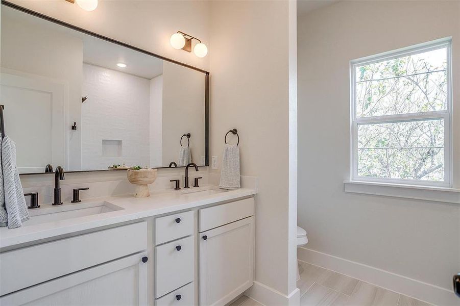 The secondary bathroom is appointed with Delta plumbing fixtures and dual sinks.