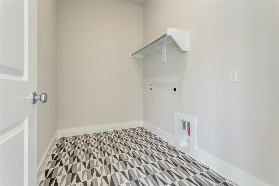 Clothes washing area with light tile patterned floors, hookup for an electric dryer, and washer hookup