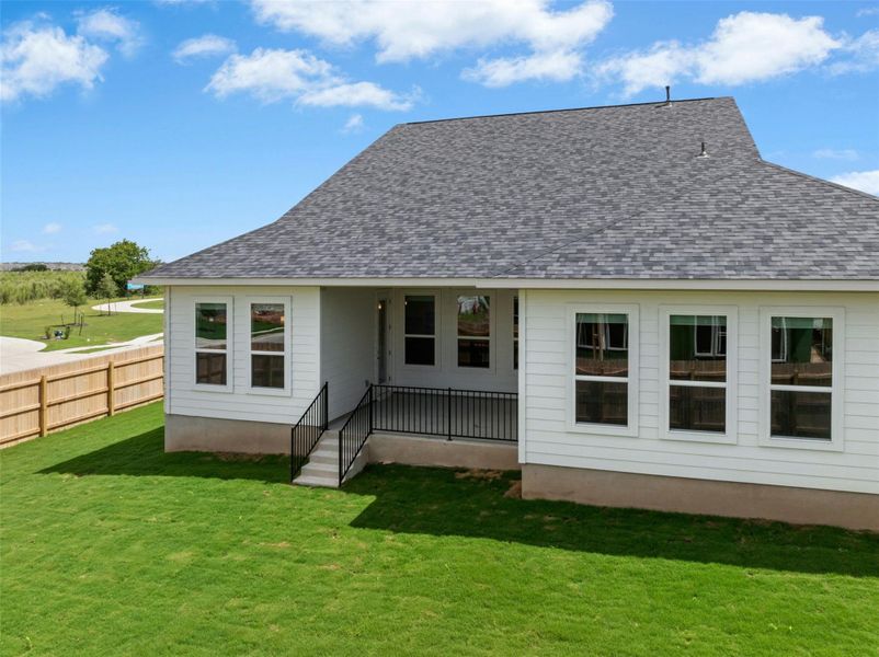 A pristine backyard oasis with lush green grass, a newly installed fence, and a modern home exterior.