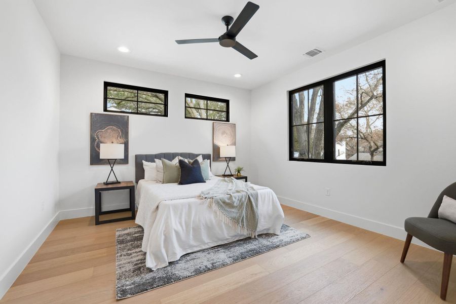 Bedroom with light wood-style floors, a ceiling fan, and recessed lighting