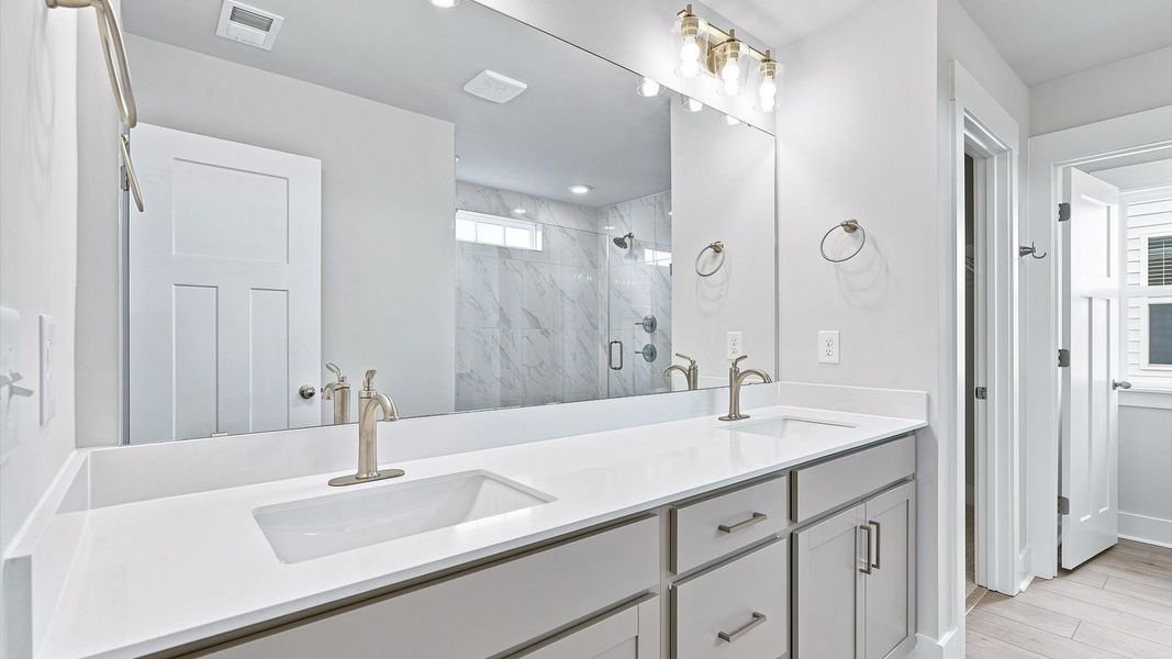 Tasteful primary bath with modern finishes, a tiled walk-in shower, and thoughtful double vanity layout Tasteful primary bath with modern finishes, a tiled walk-in shower, and thoughtful double vanity layout