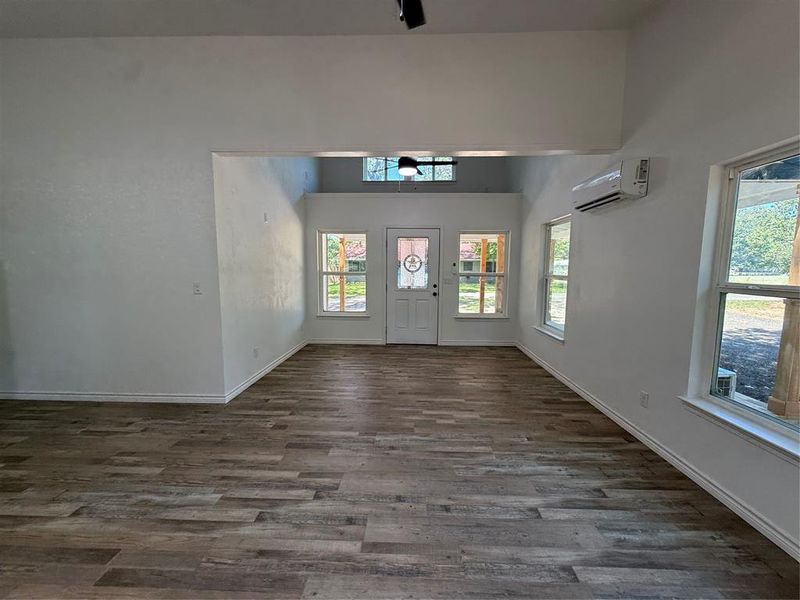 Entrance foyer with dark wood-type flooring and a towering ceiling