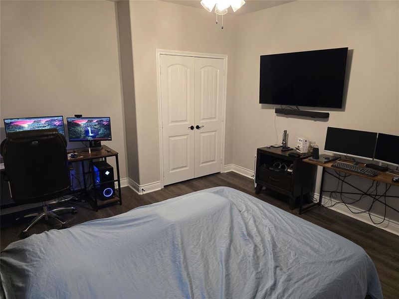 Bedroom with dark hardwood / wood-style flooring and a closet