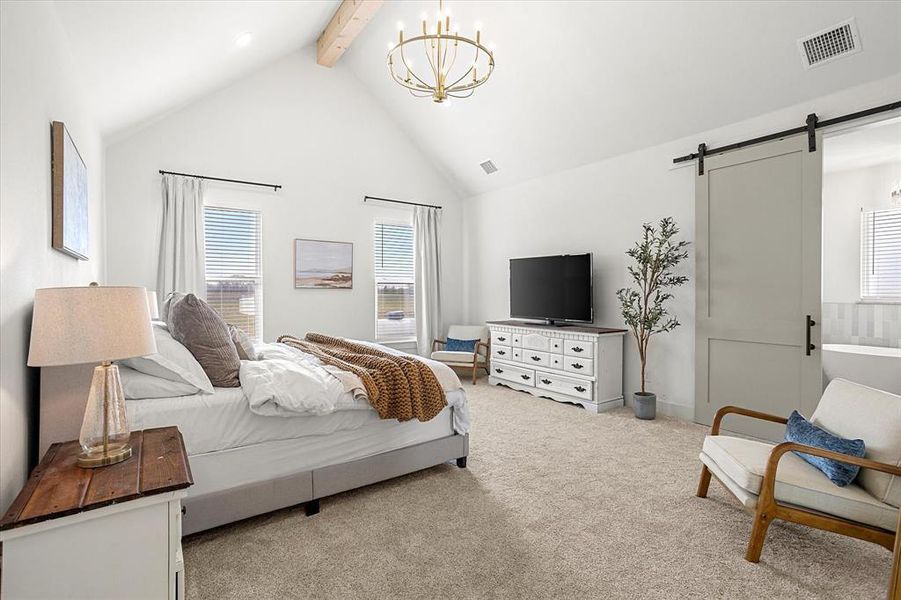 Bedroom with high vaulted ceiling, a barn door, a notable chandelier, beam ceiling, and light colored carpet