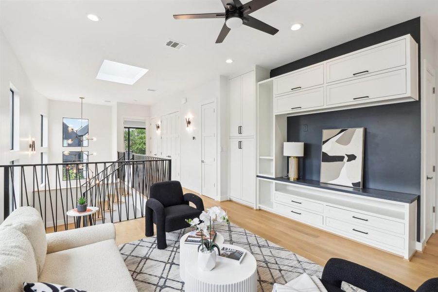 This is the second floor's living area. The room is set for a large television (where artwork sits) and is sizable for a comfortable hang-out space with comfortable furniture.