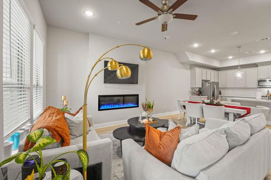 Living room with a wealth of natural light, ceiling fan, and light hardwood / wood-style flooring