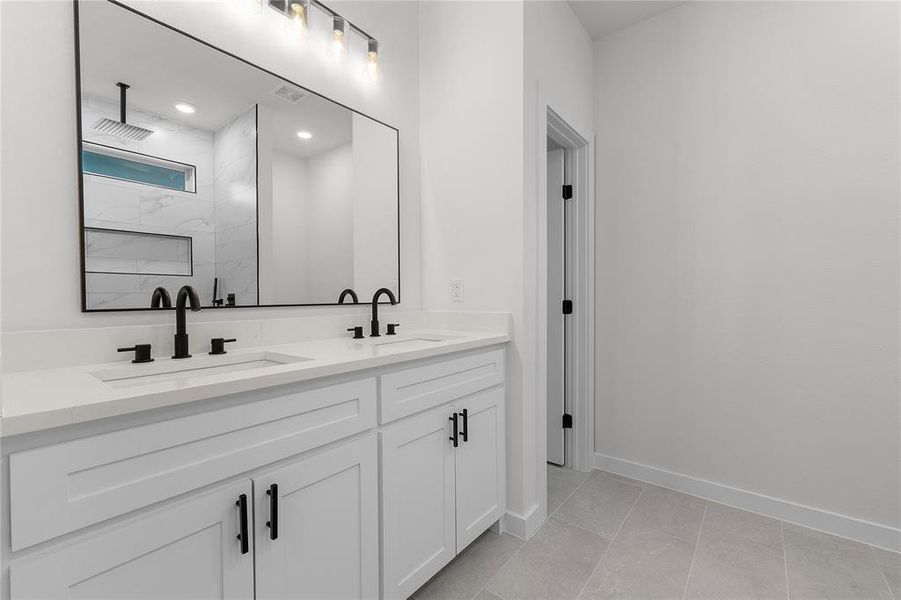 Bathroom featuring tiled shower, tile patterned flooring, and vanity