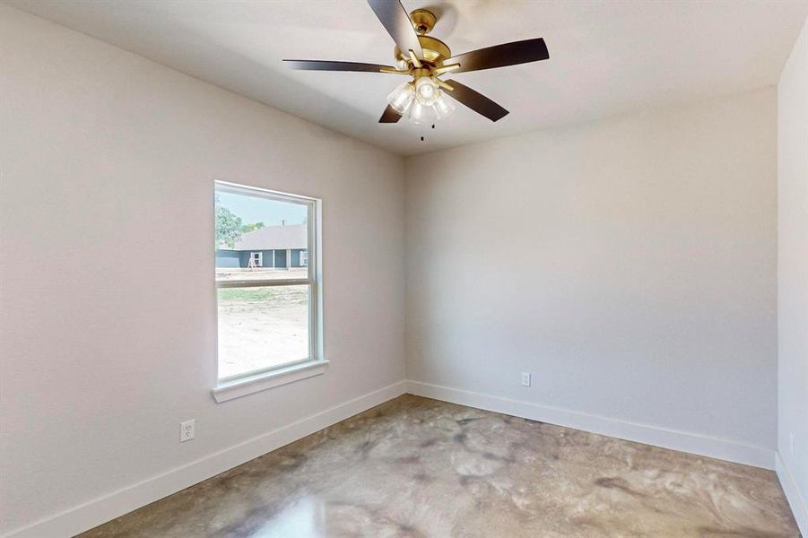 Spare room with concrete flooring and ceiling fan