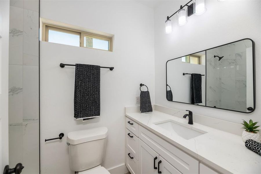 Bathroom with a marble finish shower and vanity Bathroom with a marble finish shower and vanity