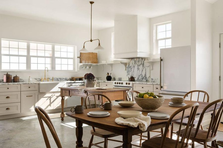 Kitchen featuring freestanding refrigerator, concrete floors, range with electric stovetop, white cabinetry, and decorative backsplash