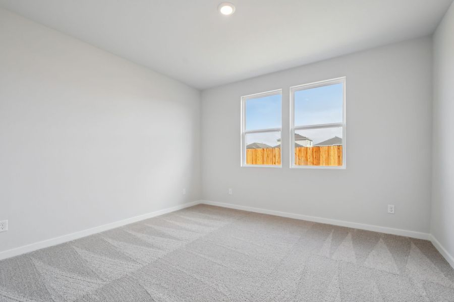 A room with a window and a white wall.