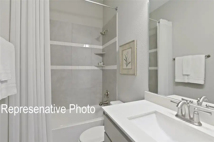 Bathroom featuring a vanity with an integrated sink, brushed nickel faucet, and a large mirror Bathroom featuring a vanity with an integrated sink, brushed nickel faucet, and a large mirror