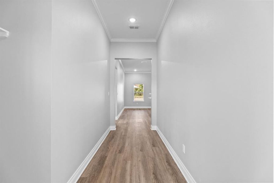 Corridor featuring crown molding, wood finished floors, and recessed lighting