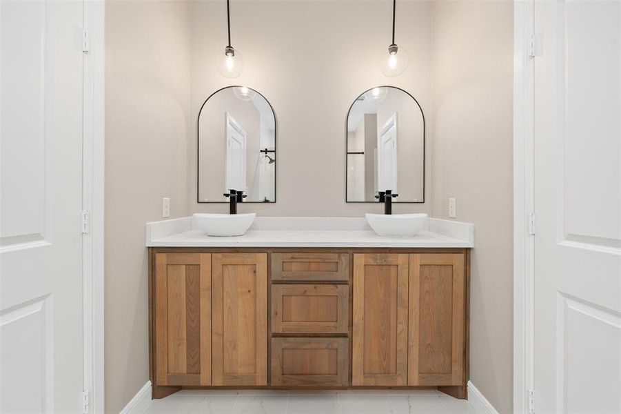 Bathroom with double vanity and baseboards