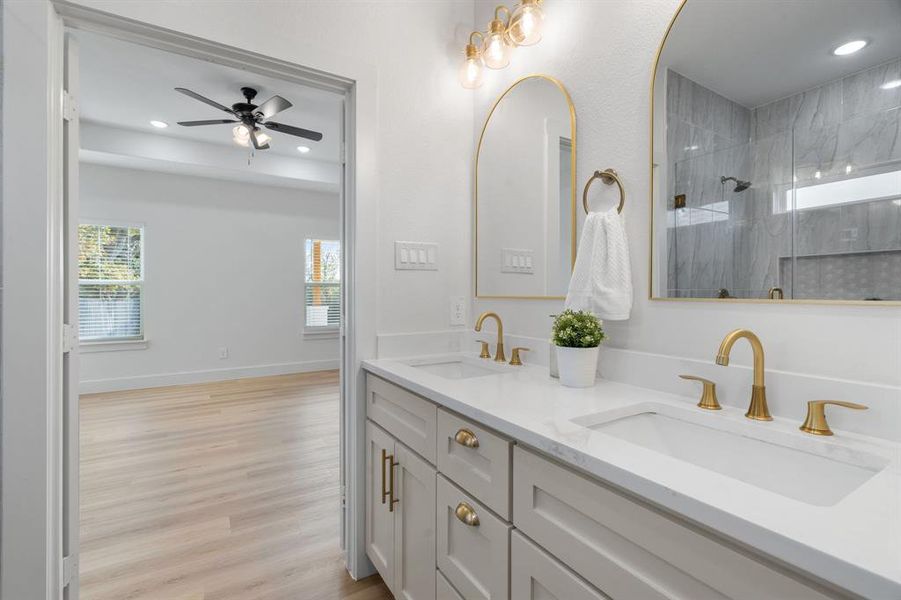 Bathroom featuring recessed lighting, double vanity, light wood finished floors, a ceiling fan, and a shower
