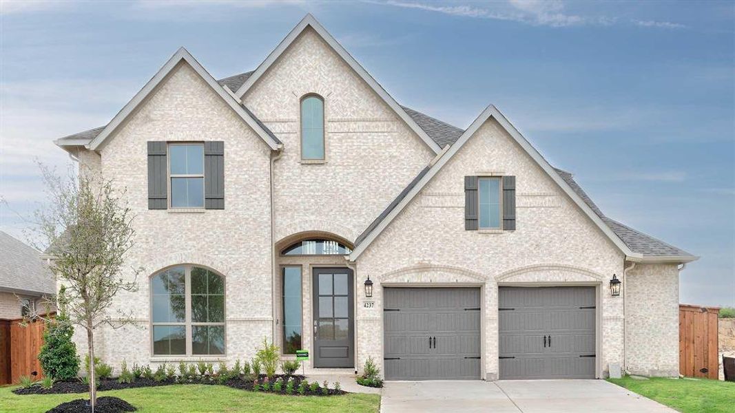 French provincial home featuring a garage and a front yard