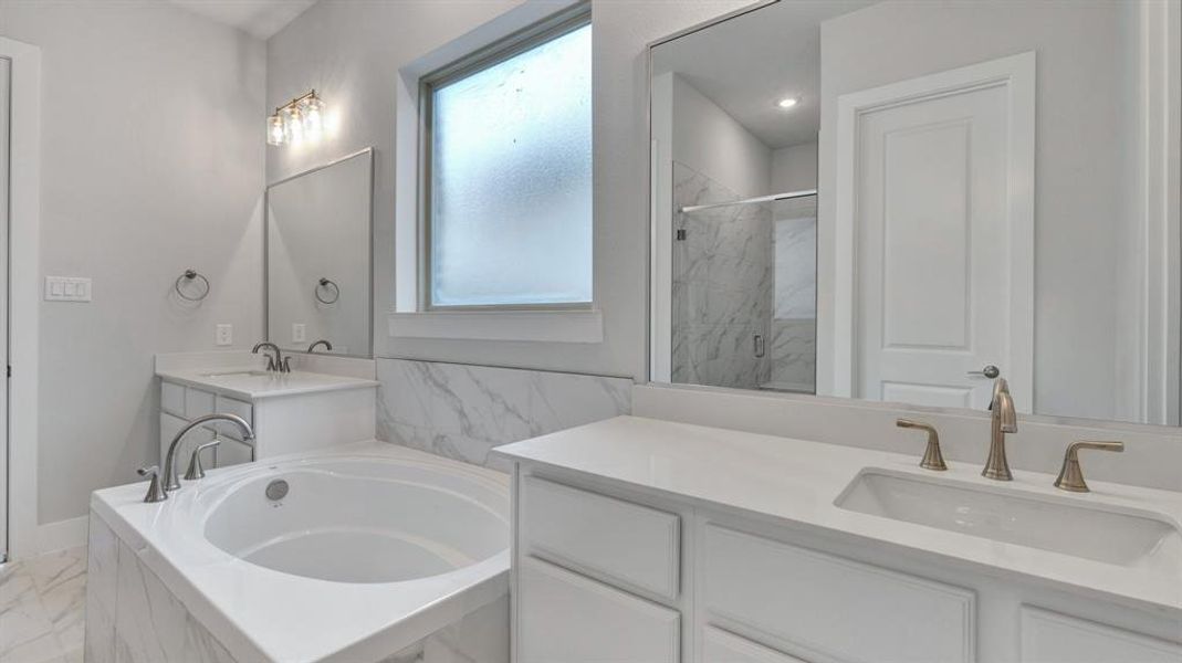 Bathroom featuring vanity and shower with separate bathtub