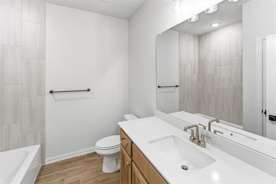 Full bath with wood tiled floors and vanity