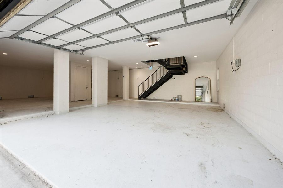 This premier garage is oversized in the parking and storage areas. Stairs lead to the living spaces and door provides access to covered, ground level patio and summer kitchen. This premier garage is oversized in the parking and storage areas. Stairs lead to the living spaces and door provides access to covered, ground level patio and summer kitchen.