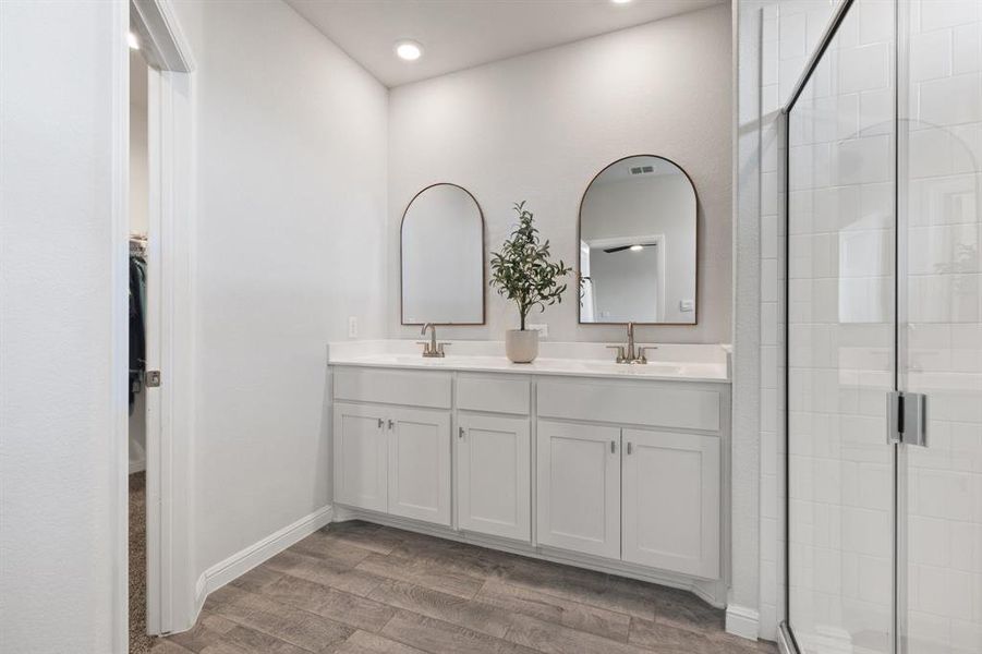 Primary Bathroom with a shower, vinyl woodd floors, double vanity, and recessed lighting Primary Bathroom with a shower, vinyl woodd floors, double vanity, and recessed lighting