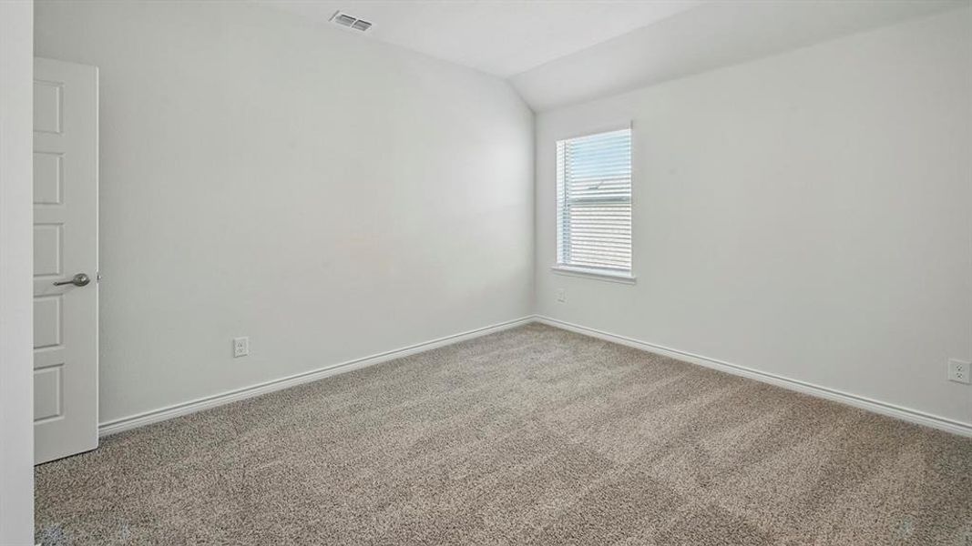 Spacious room featuring neutral carpeting, white walls, a single window with blinds, and a paneled door