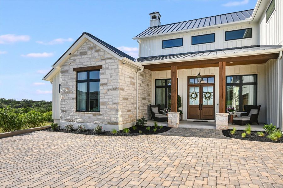 Entrance to property featuring a porch, a standing seam roof, a chimney, board and batten siding, and stone siding Entrance to property featuring a porch, a standing seam roof, a chimney, board and batten siding, and stone siding