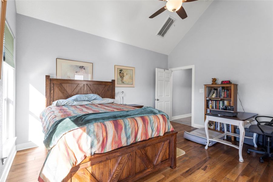 Primary Bedroom featuring lofted ceiling, hardwood  flooring, and ceiling fan