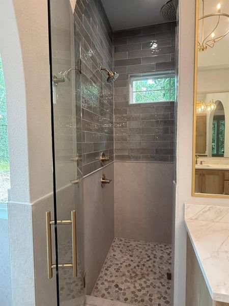 Full bath with a shower stall and vanity