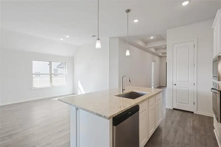 Kitchen featuring white cabinetry, an island with sink, stainless steel appliances, and open floor plan
