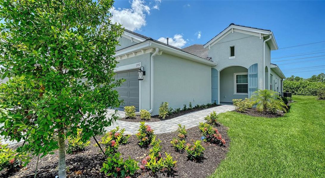 Front exterior of a new home in Windward Real Estate and Homes for Sale in Sarasota, FL - Neal Communities, Lakewood Ranch, FL, highlighting curb appeal (Image 2).