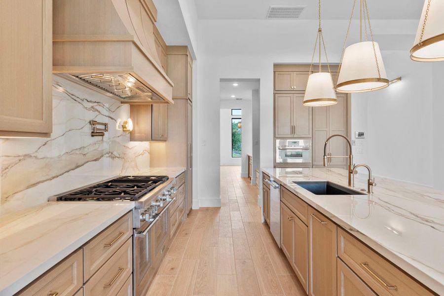 The gourmet kitchen features a large island and luxurious finishes as chosen by our award-winning design center. Representative image.