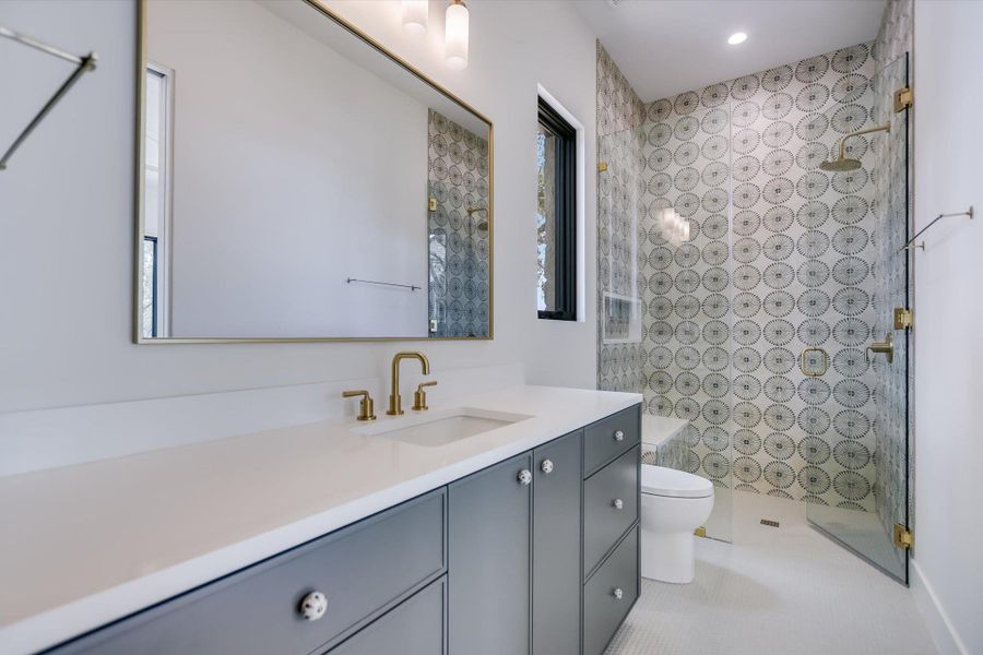 A striking patterned tile shower wall provides a focal point in this contemporary bathroom.