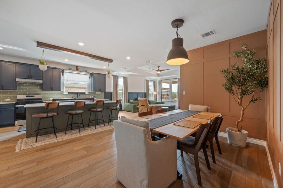 Dining space featuring a decorative wall, light wood-style flooring, a raised ceiling, recessed lighting, and a ceiling fan Dining space featuring a decorative wall, light wood-style flooring, a raised ceiling, recessed lighting, and a ceiling fan