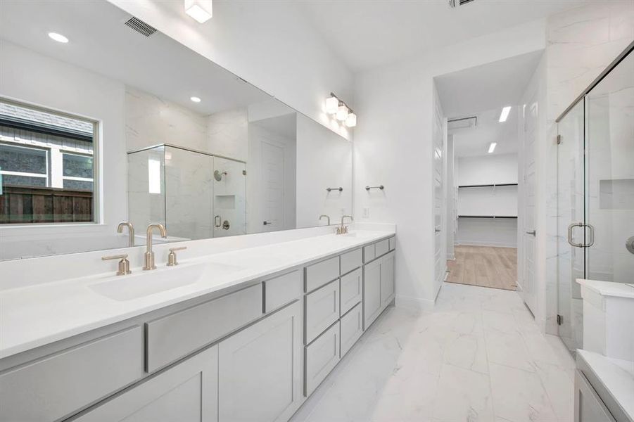 Full bathroom featuring double vanity, a marble finish shower, a spacious closet, and light marble finish flooring Full bathroom featuring double vanity, a marble finish shower, a spacious closet, and light marble finish flooring