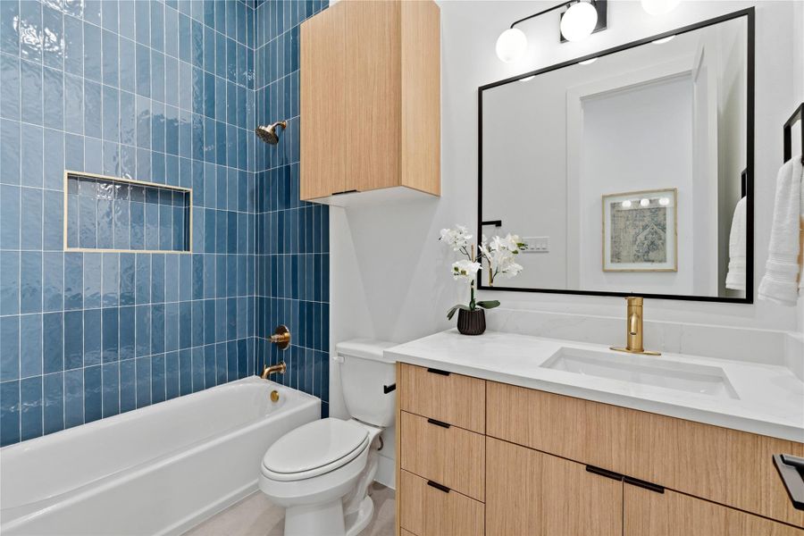 Duplex secondary bath featuring a tub/shower combo with modern tile and updated fixtures.