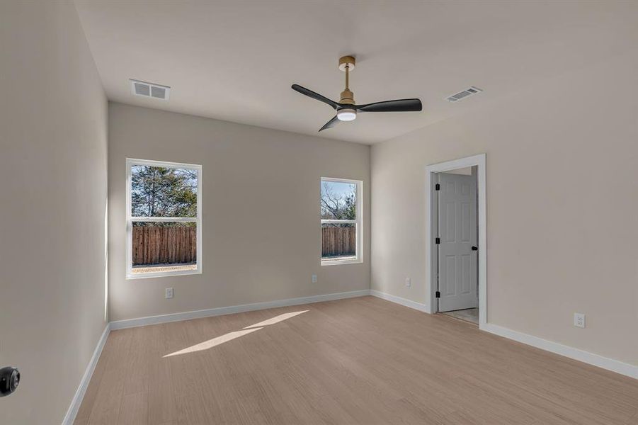 Spare room featuring ceiling fan, plenty of natural light, and light hardwood / wood-style floors