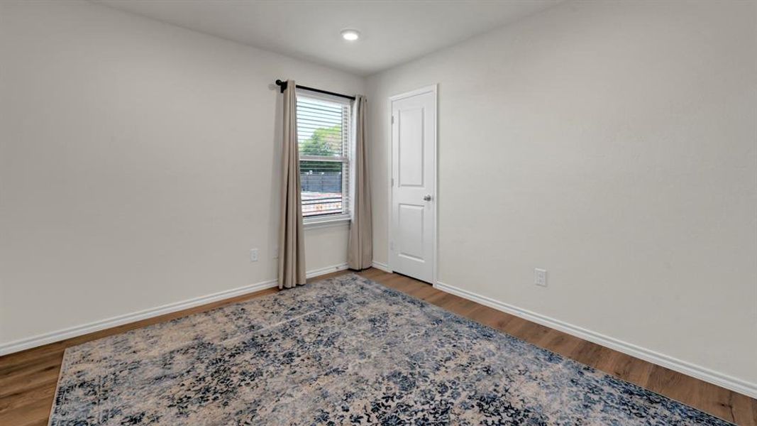 Empty room with dark wood-style floors and recessed lighting