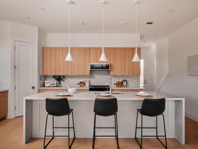 Kitchen featuring light stone countertops, light wood-style flooring, and a breakfast bar area