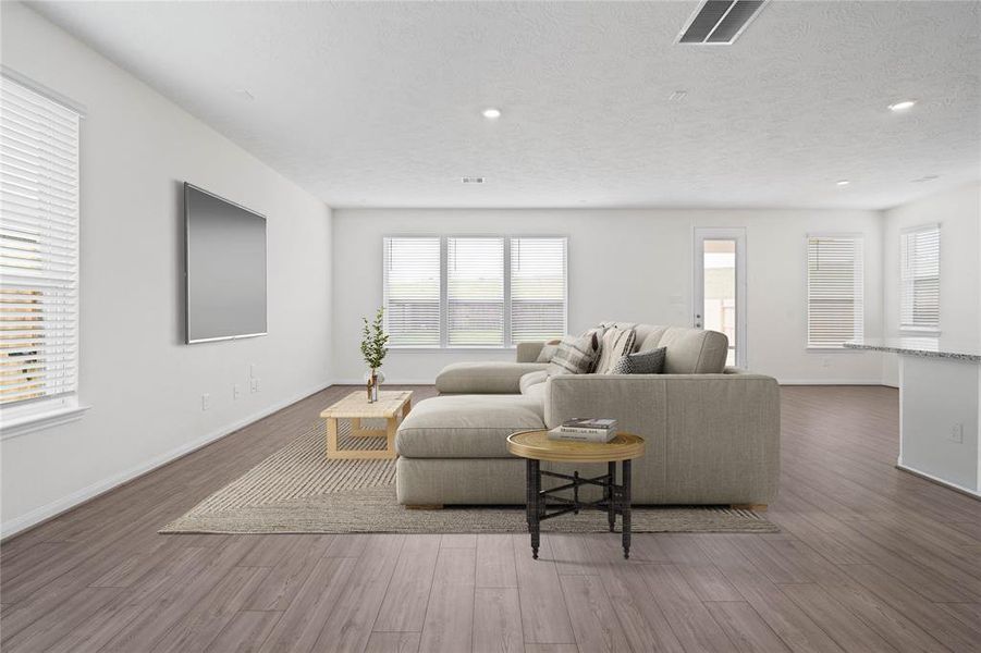 Gather the family and guests together in your lovely living room! Featuring soaring high ceilings, recessed lighting, custom paint, gorgeous vinyl plank floors, and large windows that provide plenty of natural lighting throughout the day!